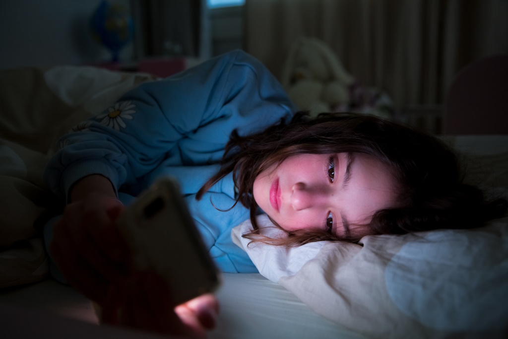 Child using mobile in bed